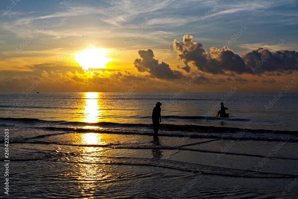 Sunrise idyllic and fisherman at the beach