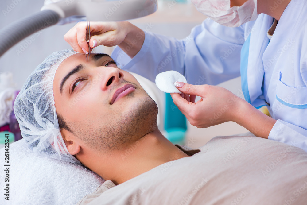 Young handsome man visiting female doctor cosmetologist Young handsome man visiting female doctor cosmetologist