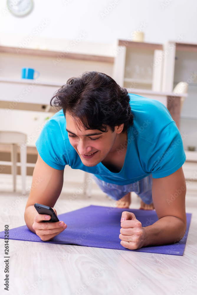 Naklejka premium Young handsome man doing morning exercises 