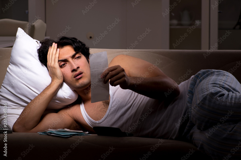 Young man calculating expences night at home Young man calculating expences night at home