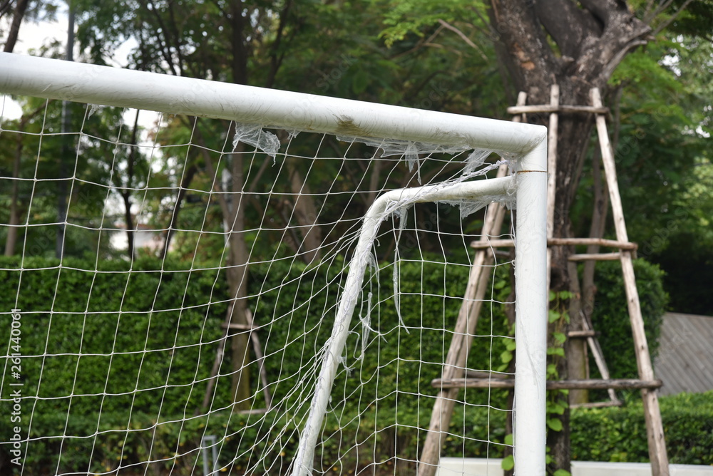 Football /soccer goal gate with net and green lawn grass background in view behind Football /soccer goal gate with net and green lawn grass background in view behind