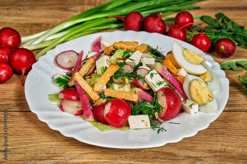 Spring salad in a bowl with radish , herbs , egg and cheese