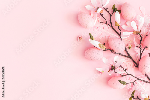 Easter composition. Easter eggs, pink flowers on pastel pink background. Flat lay, top view, copy space