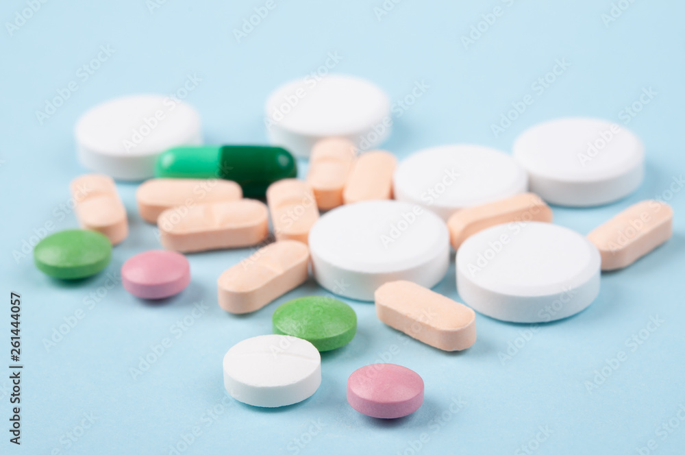 various pills , tablets and capsule of medicine on blue background. selective focus. safe drug usage concept 