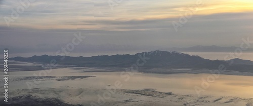 Aerial view from airplane of Antelope Island at sunset  view from Magna  sweeping cloudscape at sunrise with the Great Salt Lake State Park in winter. USA  Utah.