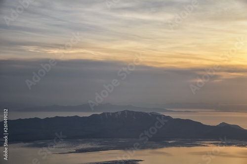 Aerial view from airplane of Antelope Island at sunset, view from Magna, sweeping cloudscape at sunrise with the Great Salt Lake State Park in winter. USA, Utah.
