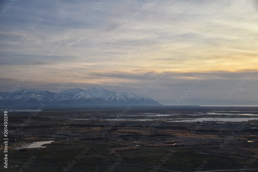 Aerial view from airplane of Antelope Island at sunset, view from Magna, sweeping cloudscape at sunrise with the Great Salt Lake State Park in winter. USA, Utah. Aerial view from airplane of Antelope Island at sunset, view from Magna, sweeping cloudscape at sunrise with the Great Salt Lake State Park in winter. USA, Utah.