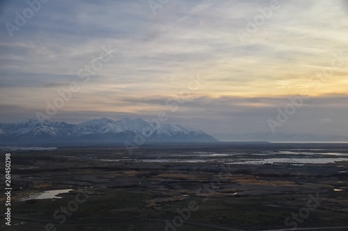 Aerial view from airplane of Antelope Island at sunset, view from Magna, sweeping cloudscape at sunrise with the Great Salt Lake State Park in winter. USA, Utah. © Jeremy