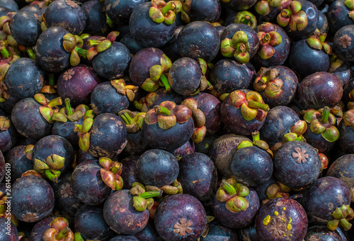 Fresh mangosteen for sale at an outdoor market. Mangosteen piles in one frame. Mangosteen is an Indonesian fruit that has purple skin. Many mangosteen to sell at the markets.