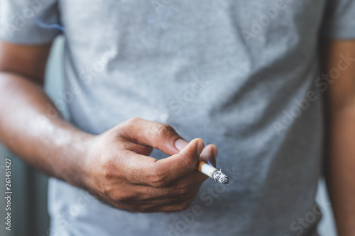 Close up male hand holding a cigarette.