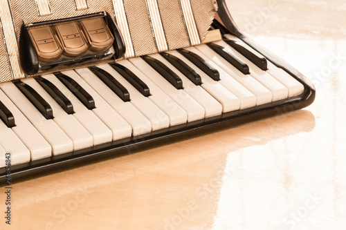 detail of old accordion on wooden table in vintage tone, close up. music concept