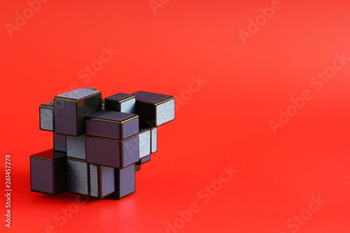 Closeup of geometric shape puzzle over red background with negative space. Science and technology concept