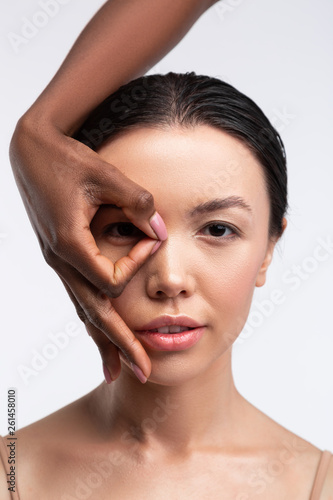 African-American woman closing face of young woman