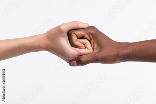 Two women with different skin color shaking their hands © Viacheslav Yakobchuk