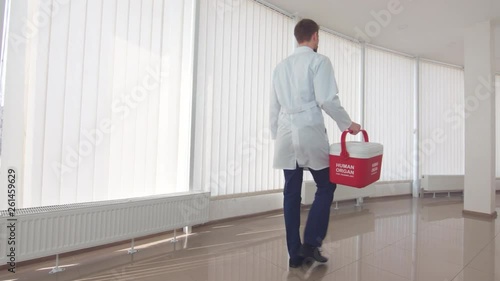 Courier stumble with human organ container in hands