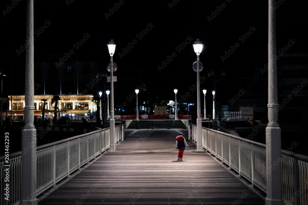 Petit garçon sur la jetée Thiers de nuit, Arcachon, France