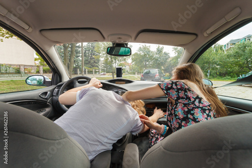 Couple in car, man fixing interior