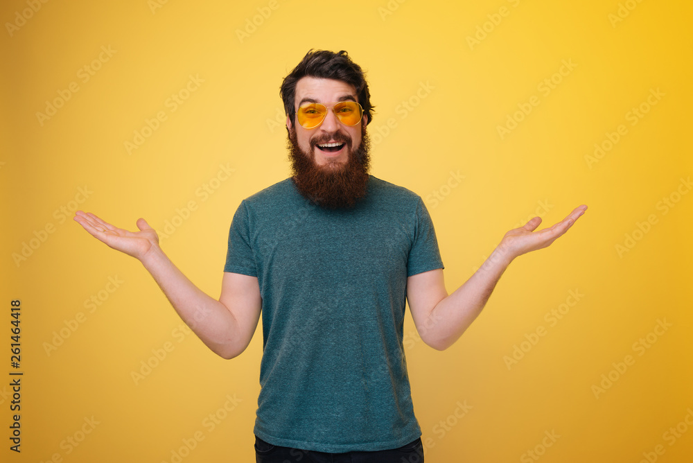 Bearded guy with rised hand, expression concept, yellow isolated background Bearded guy with rised hand, expression concept, yellow isolated background