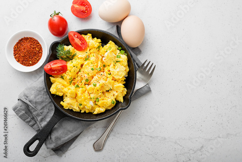 Foto Scrambled eggs on skillet over gray stone background.