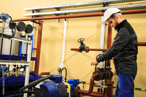 Maintenance staff checks pressure sensors on the pipeline in heating boiler plant