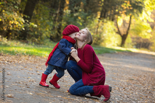 Happy family! Mother and daughter spend time in the autumn park. Laugh and play.