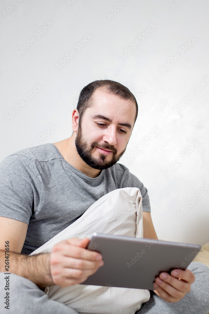 Young and beautiful man holds a tablet in his hands. Young and beautiful man holds a tablet in his hands.