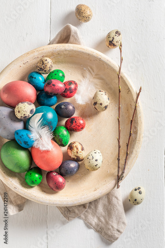 Colourfull Easter eggs on old clay plate on white table