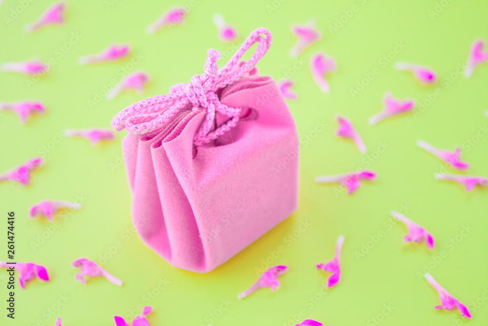 Closeup of a small gift wrapped with pink ribbon. Small gift box. Shallow depth of field. Flat lay, top view. Closeup of a small gift wrapped with pink ribbon. Small gift box. Shallow depth of field. Flat lay, top view.