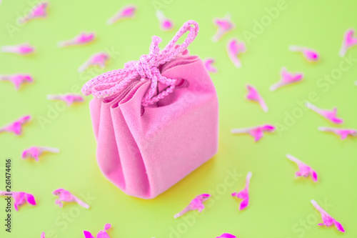 Closeup of a small gift wrapped with pink ribbon. Small gift box. Shallow depth of field. Flat lay, top view.