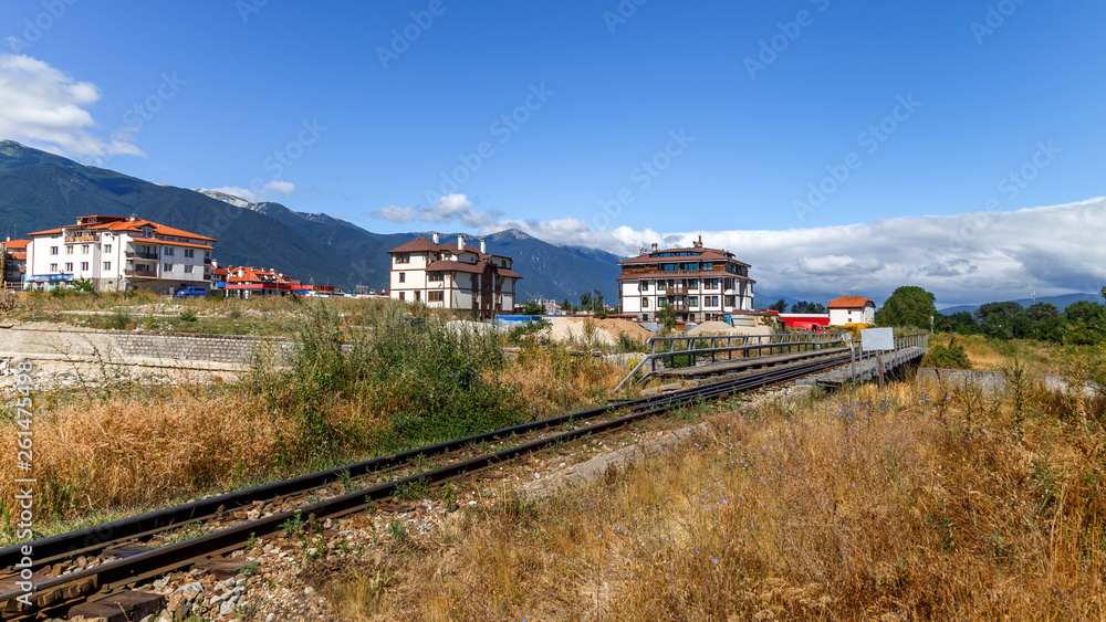 Narrow gauge railway in Bansko town, Bulgarian ski resort in summer, Pirin mountains in the background. Holidays in Bulgaria.