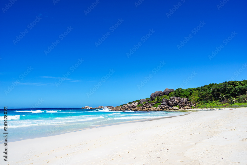 White sand, palm trees, granite rocks and turquoise water at the paradise beach at grand anse, la digue, seychelles 3