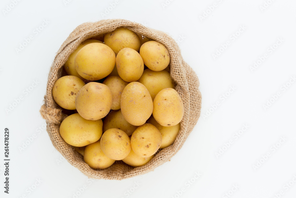 Sack of fresh raw potatoes on wooden background, top view Sack of fresh raw potatoes on wooden background, top view