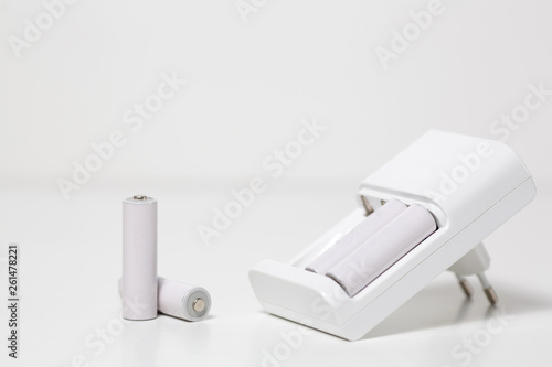 Charger with white batteries in white background.