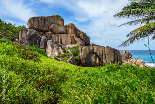 Mighty red granite rocks in lush green grass at anse songe, la digue, seychelles 5