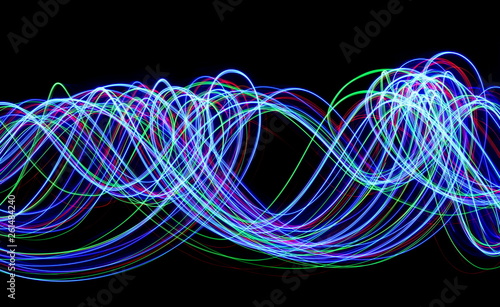 Multi color light painting photography, long exposure, electric blue, red and green, ripples and waves of vibrant color in parallel lines against a black background