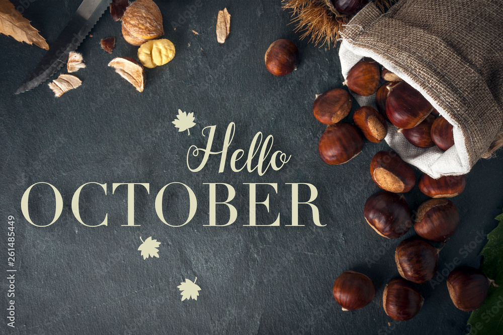 Hello october card. Roasted chestnuts on a rock table. - obrazy, fototapety, plakaty 