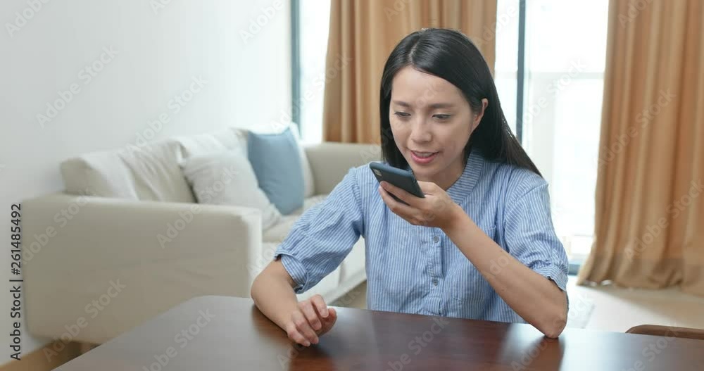 Woman send audio message on cellphone at home Woman send audio message on cellphone at home
