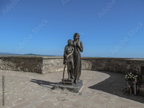 Mukachevo, Ukraine - May 3, 2018: Monument to Ilona Zrinyi and Ferenc Rakoczy (sculptor Peter Matl) at Palanok Castle. Bronze sculpture of a woman with a young teenage boy against the blue sky