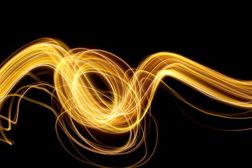 Gold light painting photography, long exposure photo of fairy lights in swirls and ripples, abstract design against a black background
