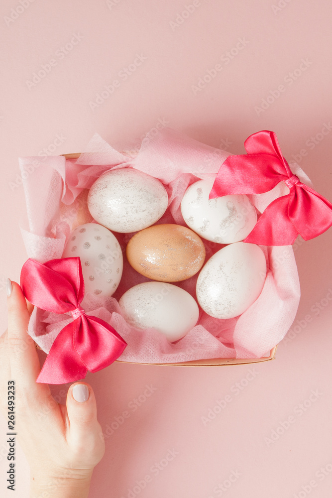 White Easter eggs in a nest on pink background. Design pastel tone in minimal flat lay White Easter eggs in a nest on pink background. Design pastel tone in minimal flat lay