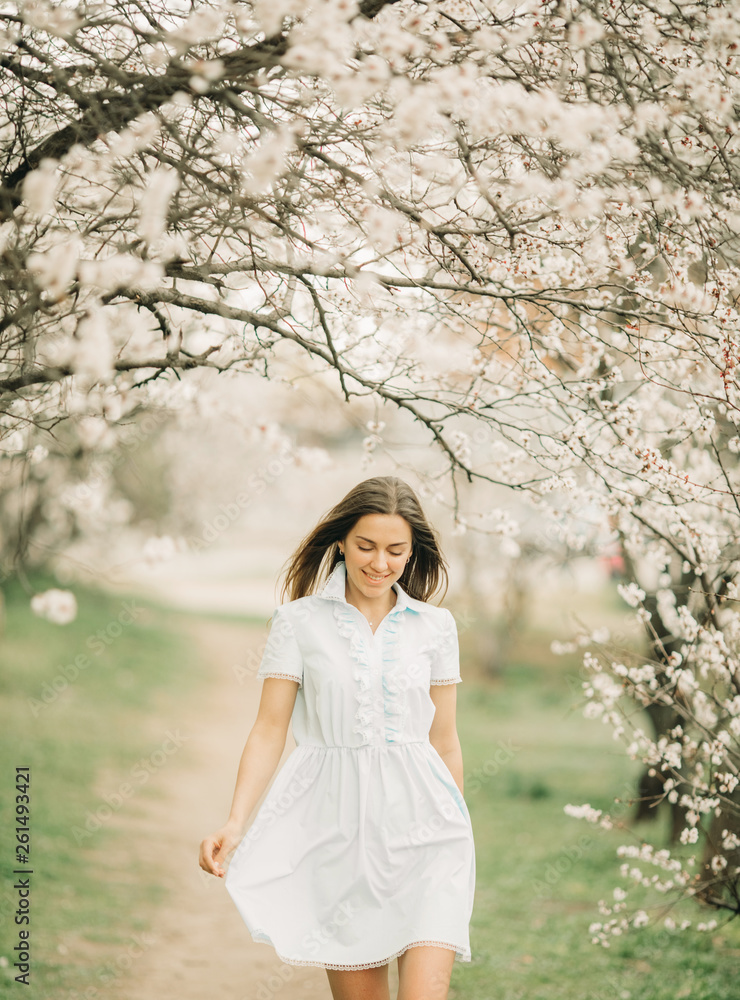 A young woman walks among the blossoming garden. A young woman walks among the blossoming garden.