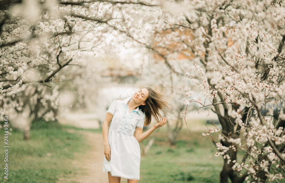 A young woman walks among the blossoming garden. A young woman walks among the blossoming garden.