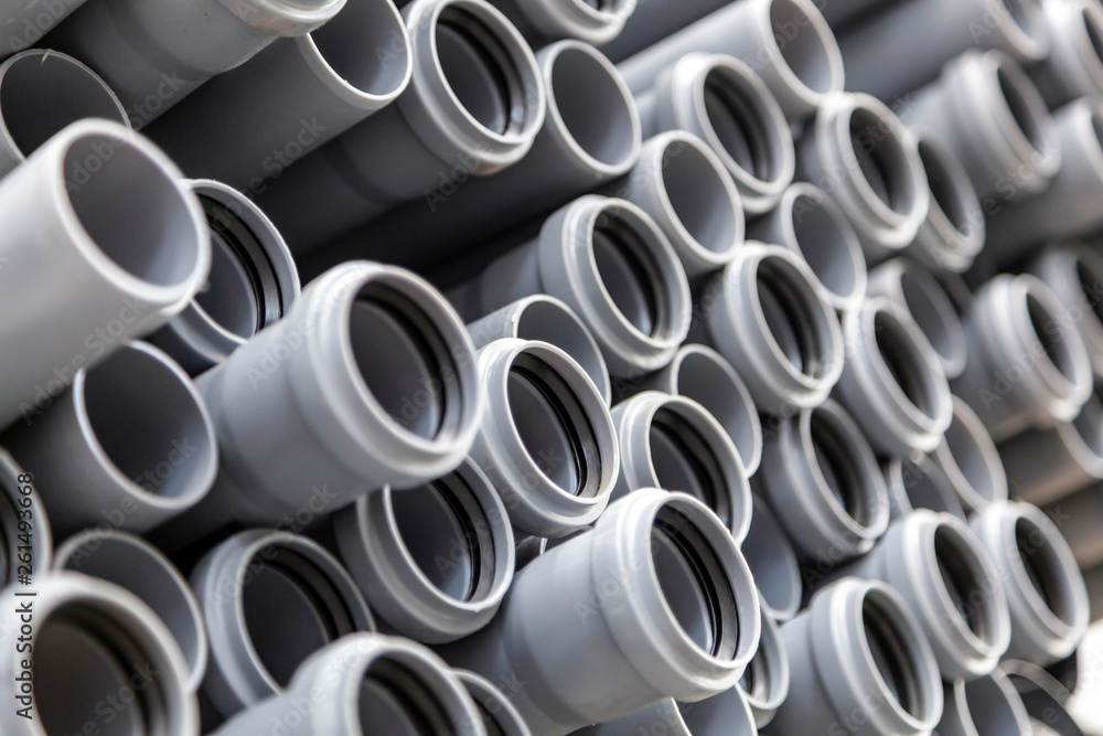 Close up gray plumbing plastic pipes. Background of colorful big plastic pipes used at the building site. Close up gray plumbing plastic pipes. Background of colorful big plastic pipes used at the building site.