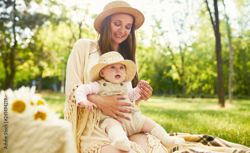 Happy stylish and loving family. mother playing with her baby outdoor. lovely baby smiles and enjoys. Mother's day concept. Lovely family spends summer day outside. photo