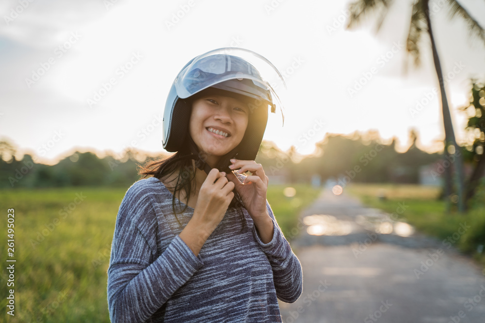 asian young woman wearing helmet fasten before motorcycling asian young woman wearing helmet fasten before motorcycling