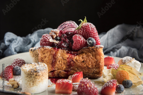 Gourmet brioche french toast with berries and marshmallows. Dark background. Horizontal. Copyspace. photo