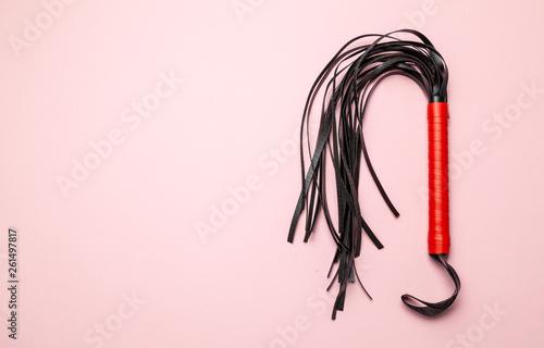 Foto Leather whip on pink background