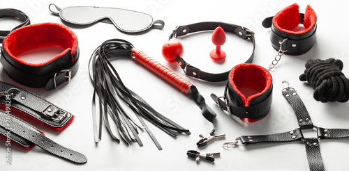 Set of erotic toys for BDSM. The game of sexual slavery with handcuffs, whip, gag and leather straps. Intimate games.