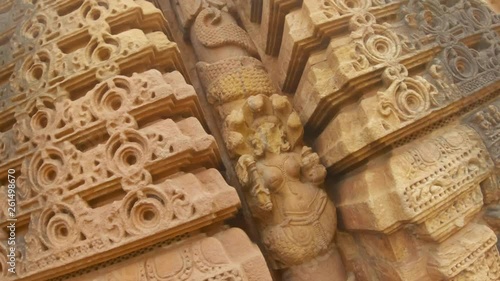 female naga deity snake tail wraps around column bas-relief on wall of ancient hindu temple Rajarani Bhubaneswar Orissa photo