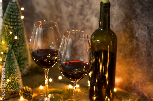 Red wine on table with Christmas lights on the background